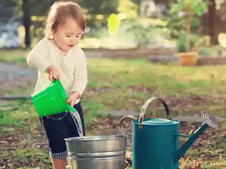 a young child with a watering pot