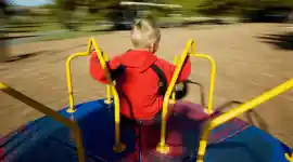 Preschool child playing on a merry go round