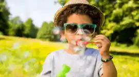 young child blowing bubbles