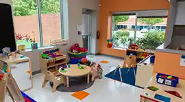 Preschool classroom with tables, storage, and books