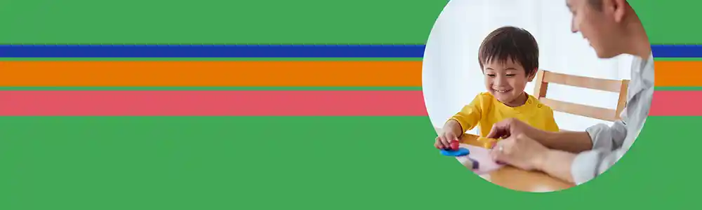 Preschool child & teacher playing at table