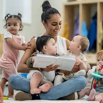 Teacher reading to infants in classroom